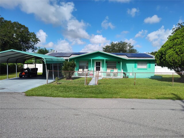 view of front of house featuring a porch, a front lawn, a carport, and solar panels