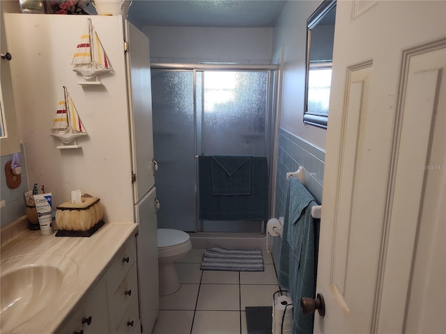 bathroom featuring vanity, toilet, a shower with shower door, and tile patterned flooring