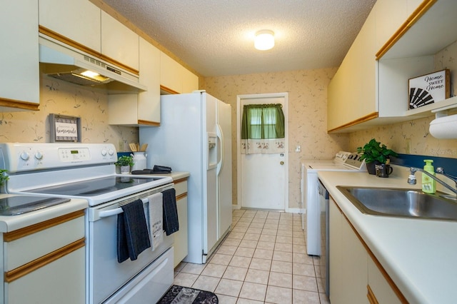 kitchen with light tile patterned floors, washer and dryer, sink, white range with electric stovetop, and a textured ceiling