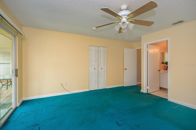 unfurnished bedroom featuring light carpet, a textured ceiling, ceiling fan, and a closet