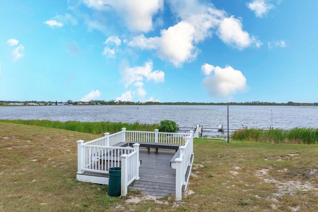 view of dock with a lawn and a deck with water view