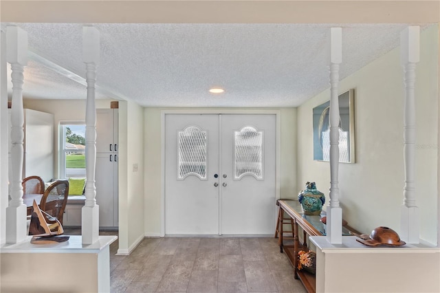 foyer entrance with french doors and a textured ceiling