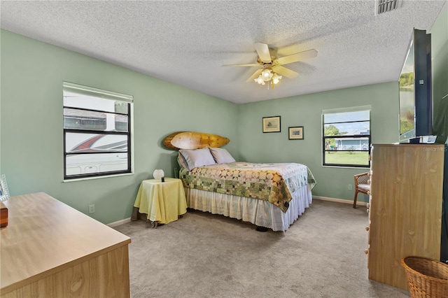 carpeted bedroom with a textured ceiling and ceiling fan