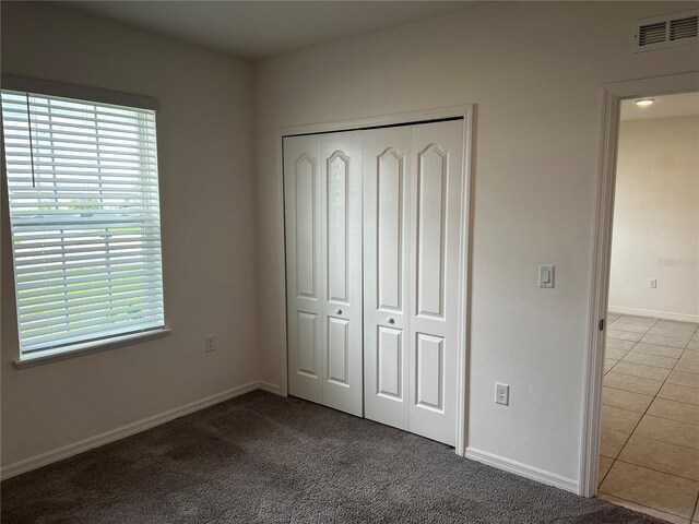 177 Cimarron Ln, Kissimmee, FL 34759 - unfurnished bedroom with a closet, baseboards, and carpet flooring