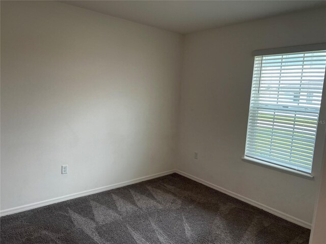 177 Cimarron Ln, Kissimmee, FL 34759 - empty room featuring dark colored carpet and baseboards