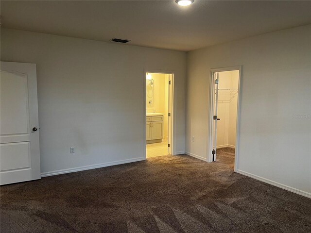 177 Cimarron Ln, Kissimmee, FL 34759 - unfurnished bedroom with carpet floors, a spacious closet, baseboards, and ensuite bathroom