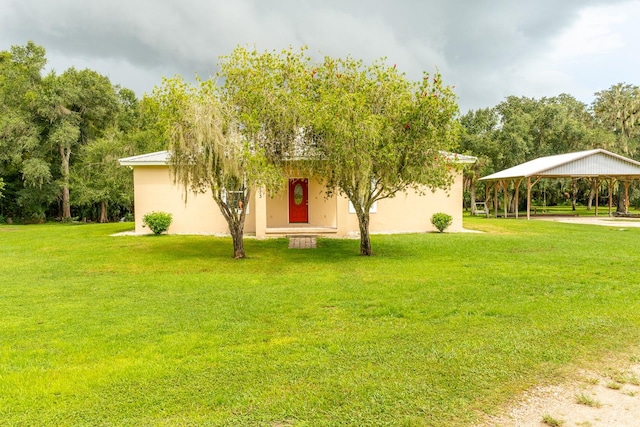 view of front of house with a carport and a front lawn