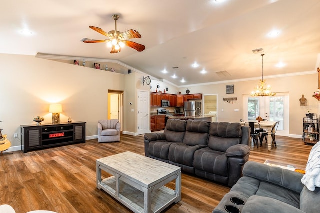 living room featuring lofted ceiling, hardwood / wood-style floors, ceiling fan with notable chandelier, and ornamental molding