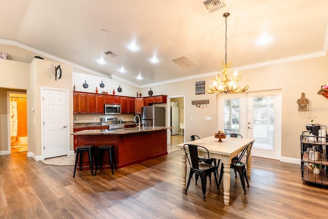 dining space featuring crown molding, lofted ceiling, hardwood / wood-style floors, and sink