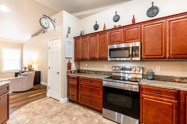 kitchen featuring stone countertops, stainless steel appliances, crown molding, and light wood-type flooring