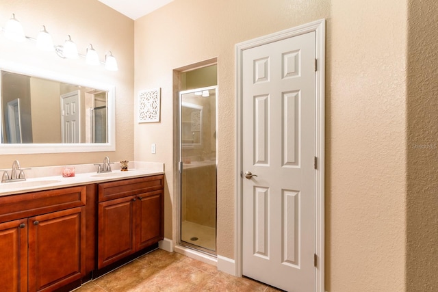 bathroom featuring tile patterned floors, an enclosed shower, and vanity