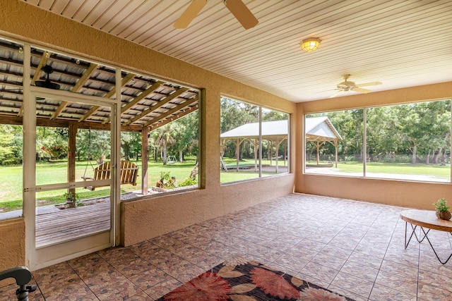 unfurnished sunroom featuring wood ceiling and ceiling fan