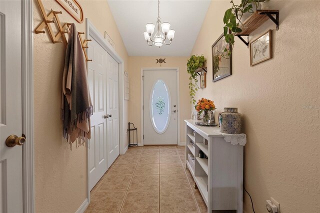 doorway to outside with vaulted ceiling, a chandelier, and light tile patterned floors