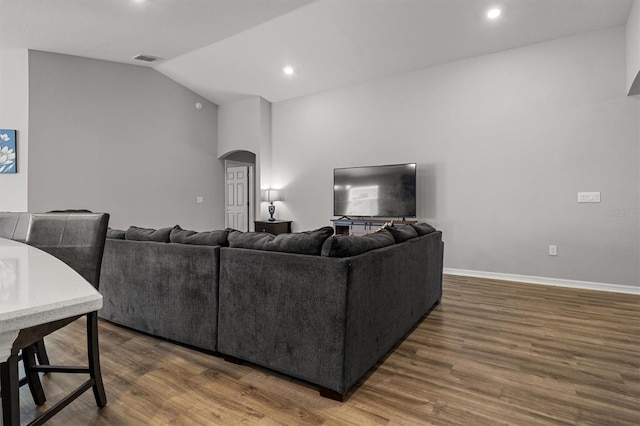 living room featuring lofted ceiling and hardwood / wood-style flooring