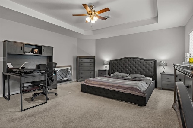 bedroom with light carpet, a raised ceiling, and ceiling fan