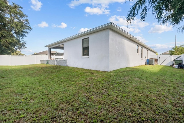 back of property with a lawn and central AC unit