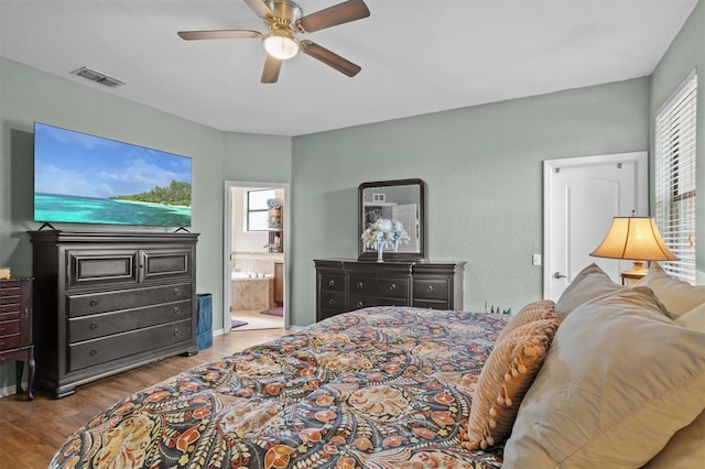 bedroom with ceiling fan, light wood-type flooring, and connected bathroom