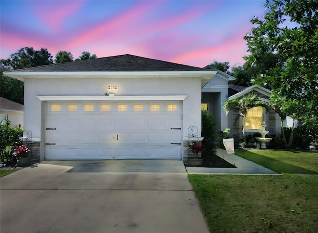 single story home featuring stone siding, an attached garage, stucco siding, and concrete driveway