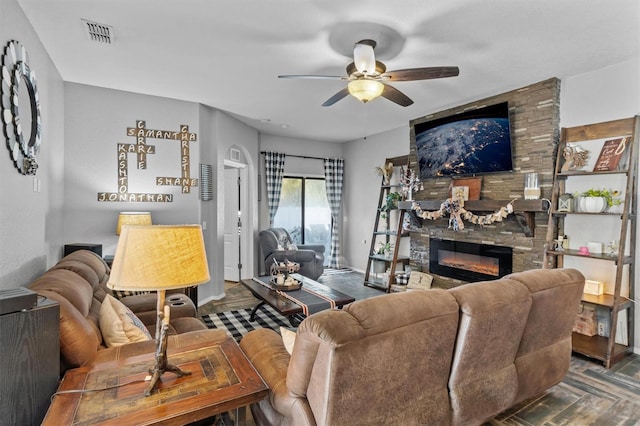 living area featuring visible vents, a fireplace, and ceiling fan