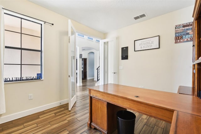 home office featuring dark wood-type flooring and a wealth of natural light