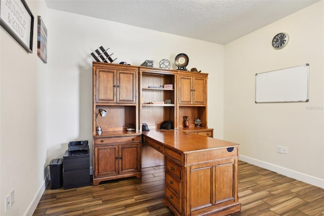 home office featuring dark wood-type flooring and a textured ceiling