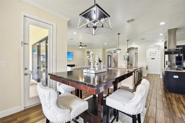 dining space with ceiling fan, dark hardwood / wood-style flooring, a textured ceiling, and sink