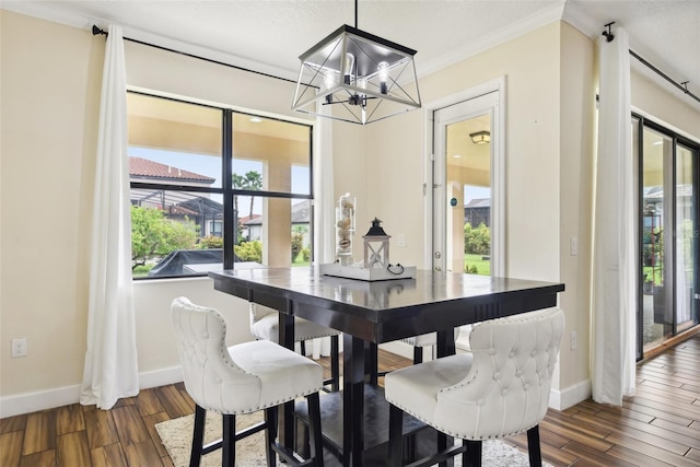 dining space with crown molding, dark hardwood / wood-style floors, and a chandelier