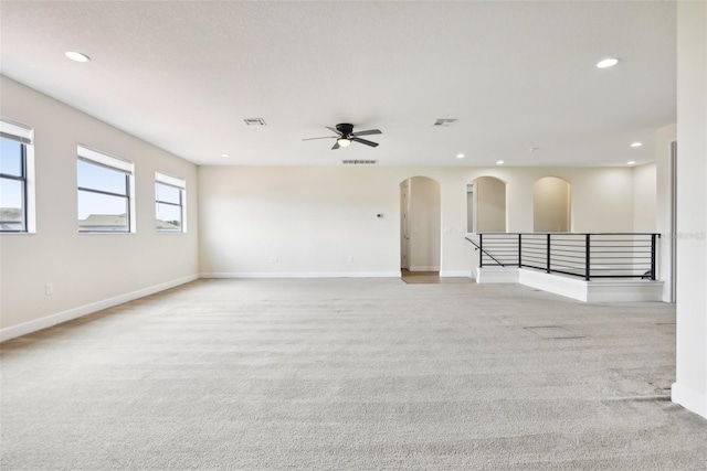 carpeted spare room featuring ceiling fan