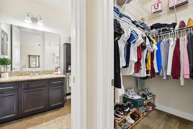 walk in closet with sink and light tile patterned floors