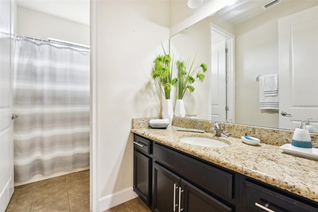 bathroom with tile patterned flooring, walk in shower, and vanity