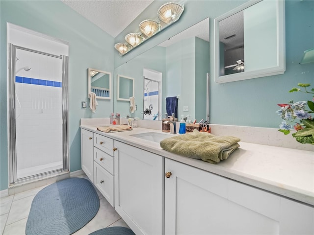 bathroom featuring vanity, a textured ceiling, walk in shower, and tile patterned floors