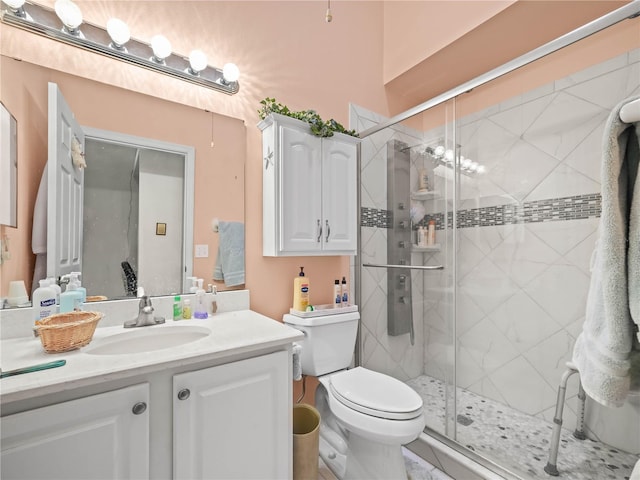 bathroom with walk in shower, toilet, and vanity