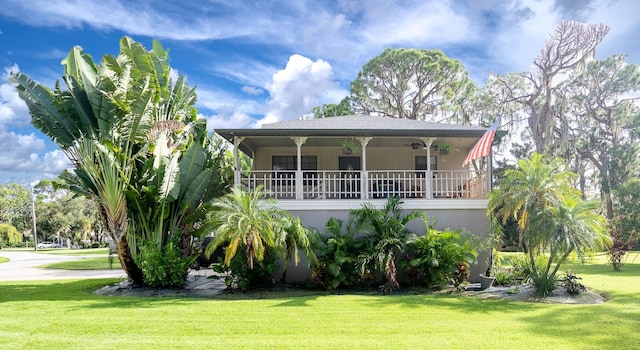 view of front of house featuring a balcony and a front lawn