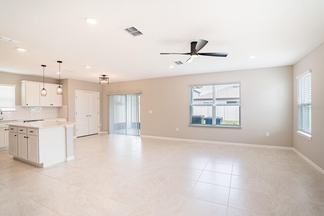 kitchen featuring plenty of natural light, a kitchen island, ceiling fan, and hanging light fixtures