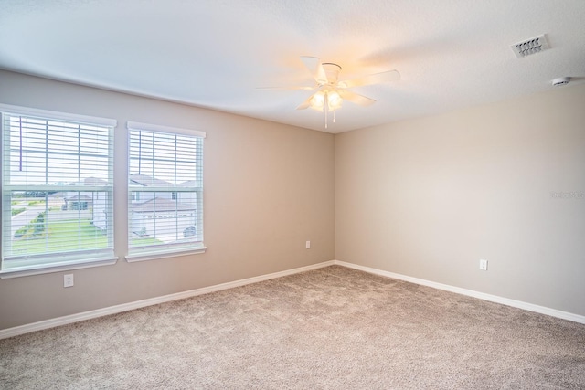 carpeted empty room with ceiling fan and a textured ceiling