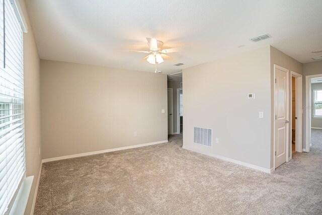 carpeted spare room featuring ceiling fan