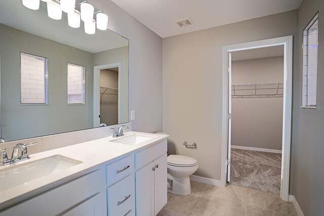 bathroom featuring vanity, toilet, and tile patterned flooring