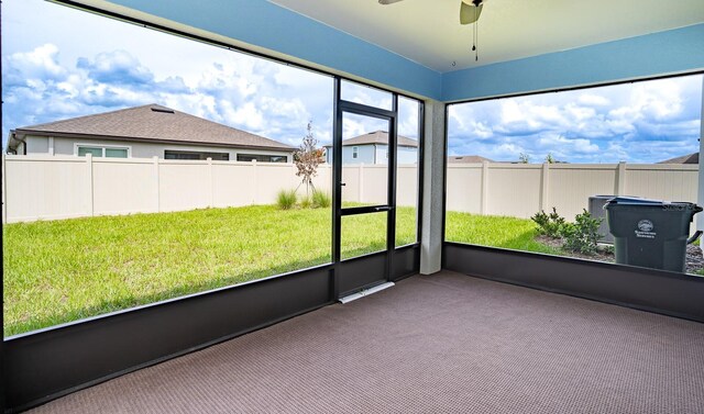 unfurnished sunroom with ceiling fan