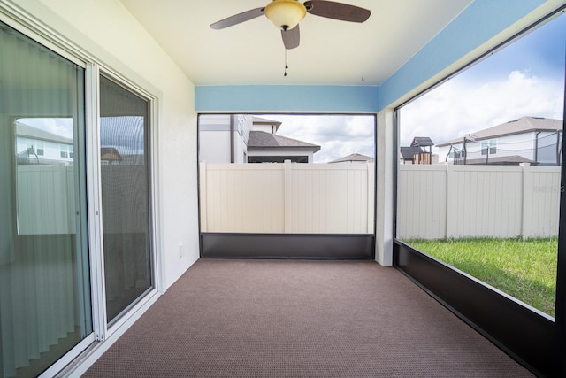 unfurnished sunroom with ceiling fan