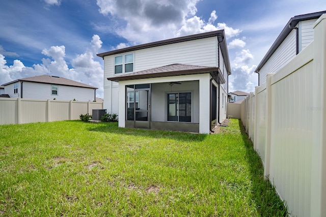 rear view of house with a yard, cooling unit, and ceiling fan