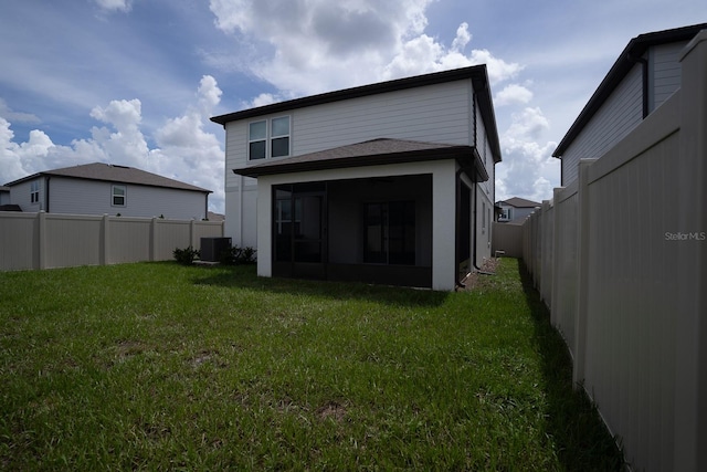 back of house featuring cooling unit, a yard, and a sunroom