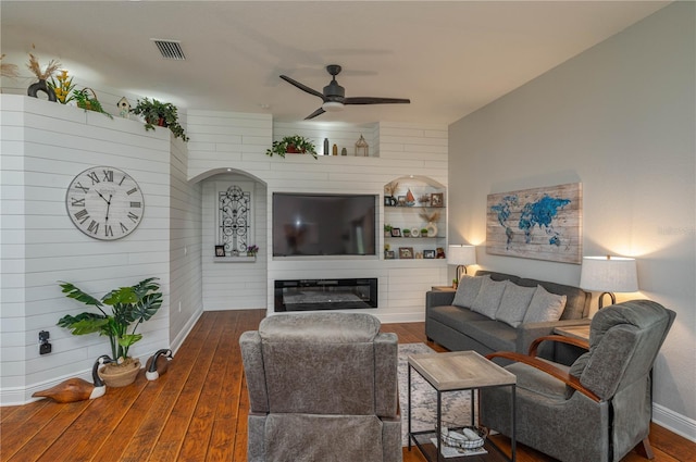 living room featuring ceiling fan and dark hardwood / wood-style floors