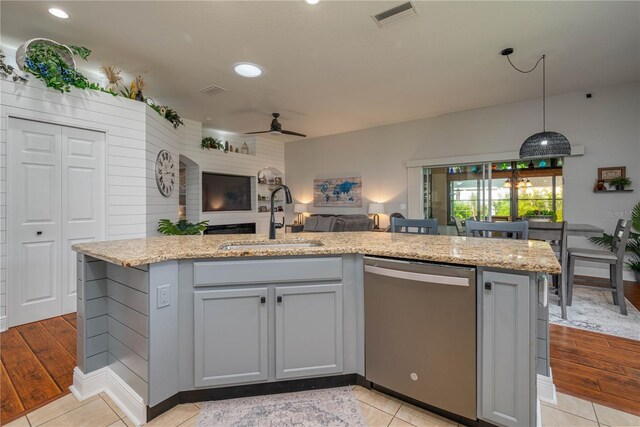 kitchen with dishwasher, ceiling fan, sink, and light hardwood / wood-style floors