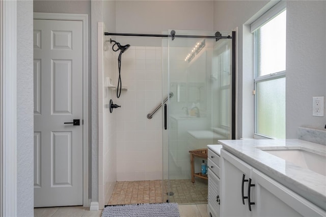 bathroom featuring vanity, tile patterned floors, and walk in shower