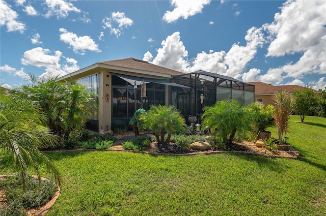 back of house featuring a lawn and a lanai