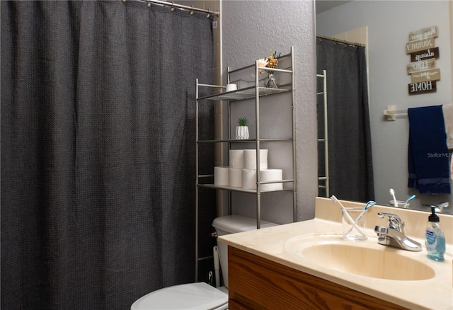 bathroom featuring curtained shower, toilet, and vanity