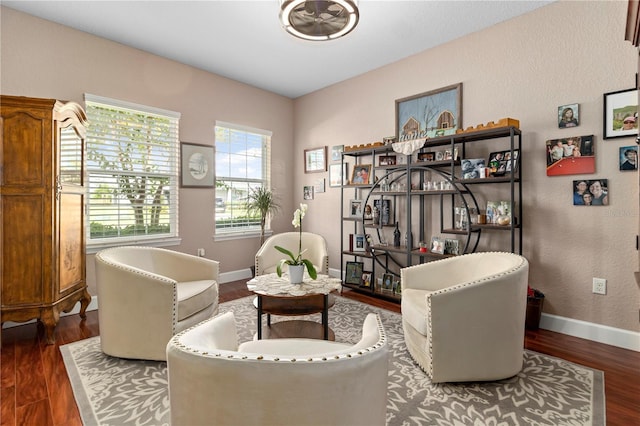 living area with dark wood-type flooring and ceiling fan