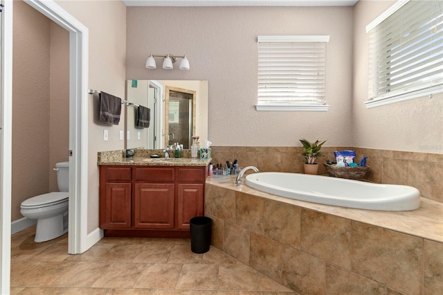 bathroom featuring toilet, tiled bath, and vanity