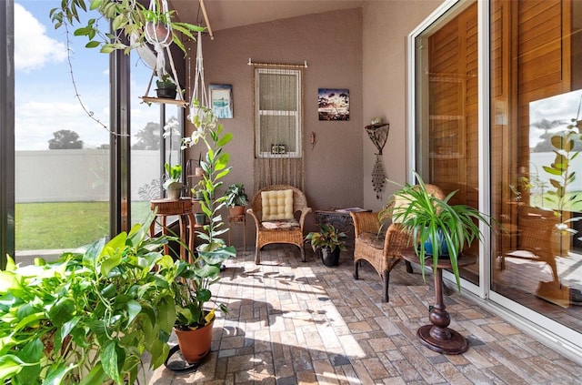 sunroom / solarium featuring vaulted ceiling