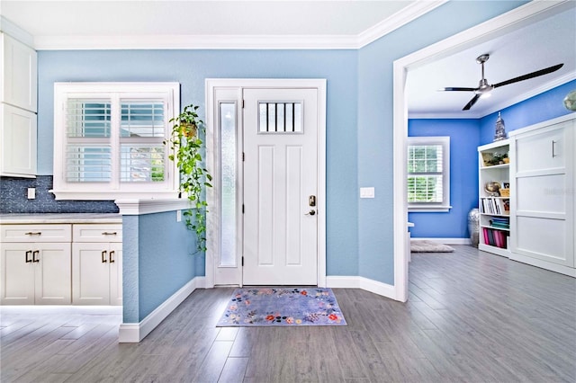 foyer entrance featuring hardwood / wood-style floors, ceiling fan, and crown molding